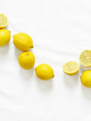 whole and halved lemons on a marble table
